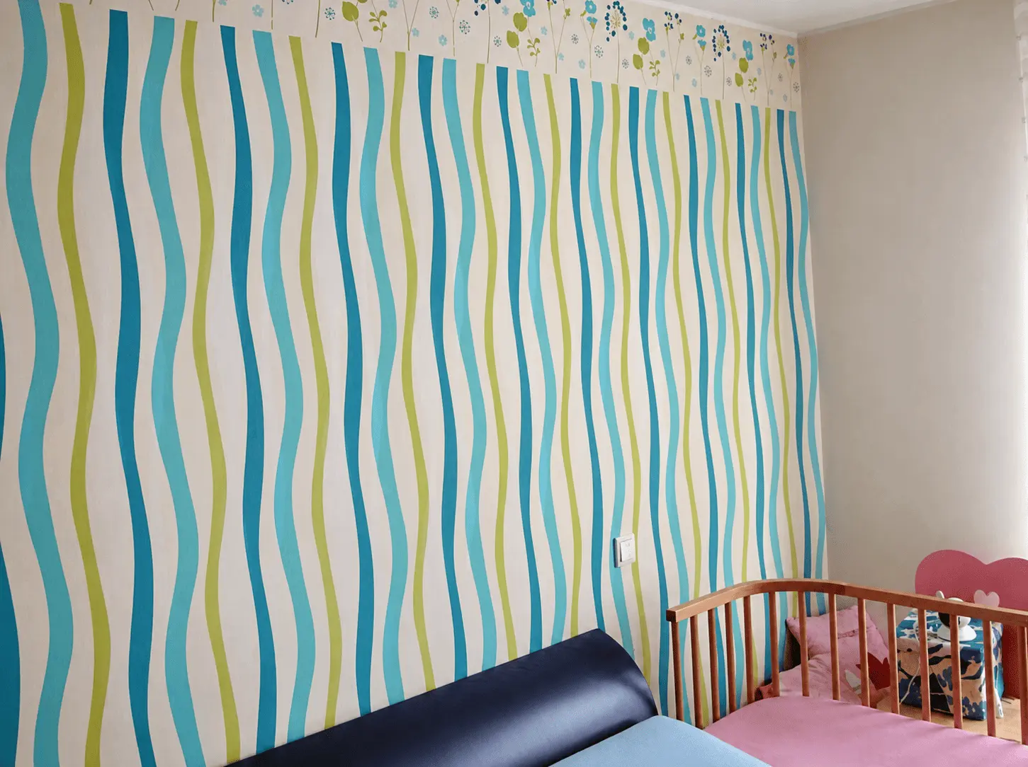 Kinderzimmer mit blau-grün gemusterter Tapete nach Tapezierarbeiten in Bochum