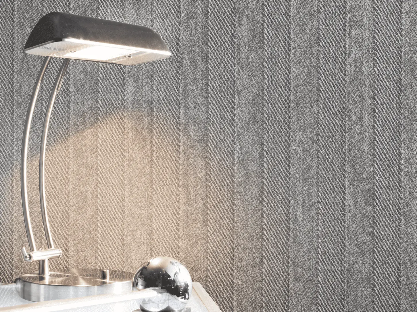 Graue Strukturtapete mit moderner Lampe nach professionellen Tapezierarbeiten in Bochum